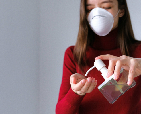 Mulher com máscara a pôr desinfetante